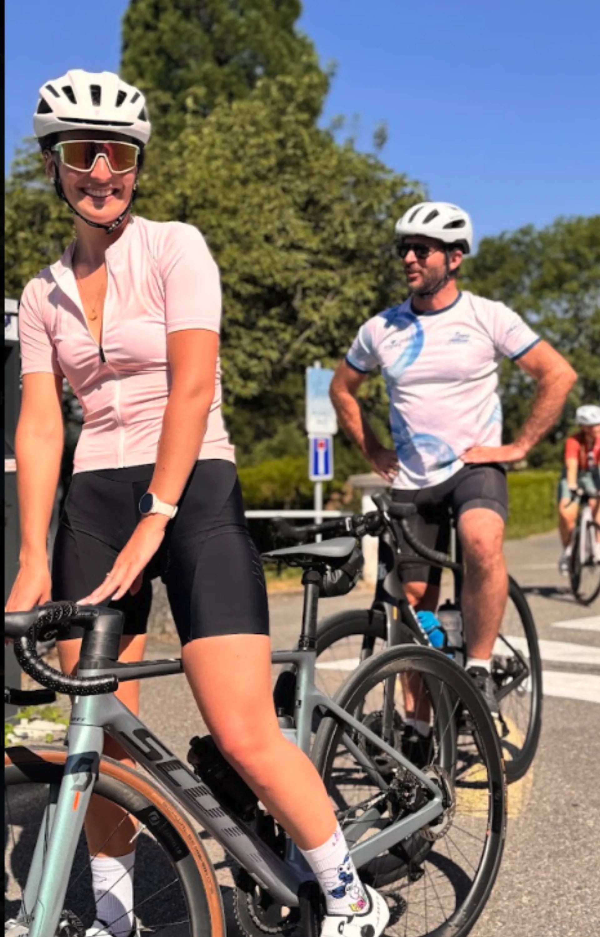 Cycliste souriante et participants à l'arrêt pendant une sortie vélo communautaire estivale