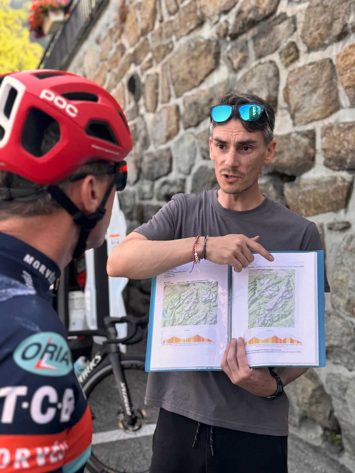Guide présentant la carte et le profil de l'itinéraire vélo dans les Alpes aux participants
