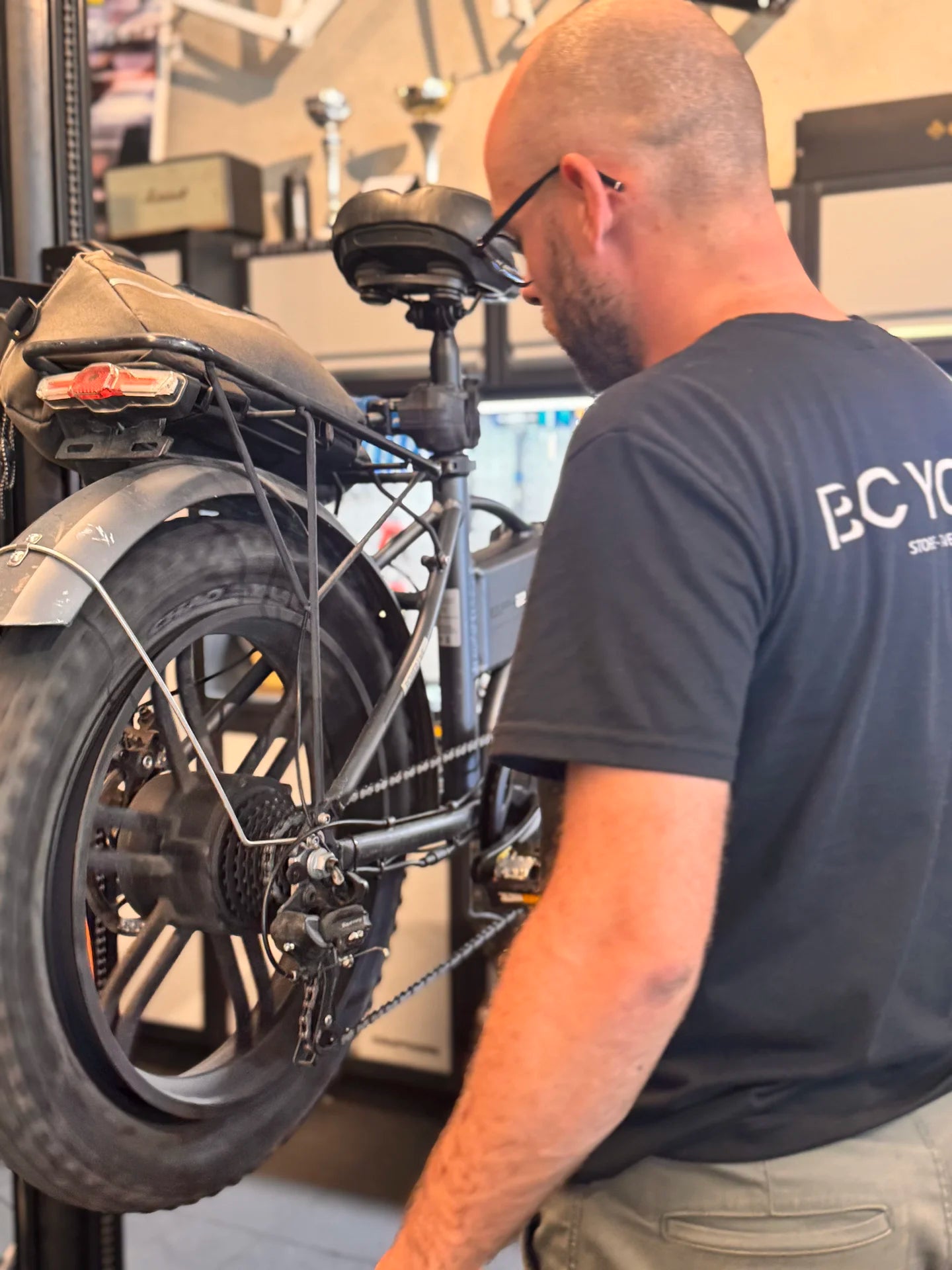 Réparation d'un fat bike électrique sur pied d'atelier par un mécanicien Bcyclet