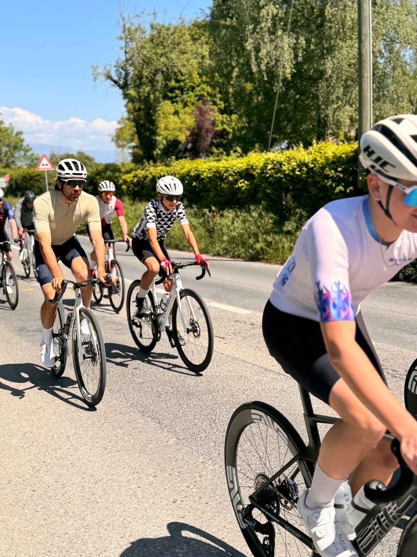 Peloton du ride communautaire Bcyclet roulant sur une route de campagne dans les Alpes
